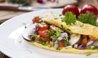 Deftiger Eierkuchen mit Tomatensalat und Champignons