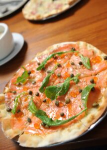 Dinkel-Flammkuchen mit Lachs und Tomaten-Rucolasalat