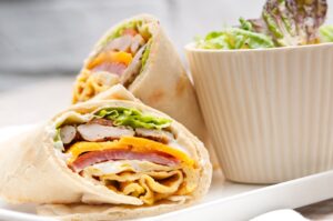 Wrap mit Putenwurst, gekochten Schinken, Paprika und Tomaten