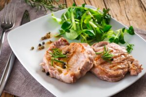 Gegrillte Schweinesteaks mit Feldsalat