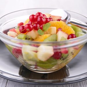 Obstsalat mit Orange, Apfel, Kiwi und Johannisbeeren