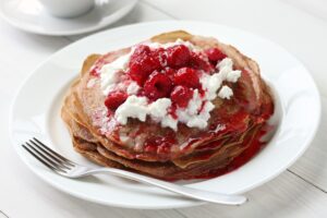 Apfel-Pfannkuchen mit heißen Himbeeren und Hüttenkäse