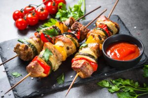 Schweinefleisch-Spieße mit Gemüse und Tomatensalat