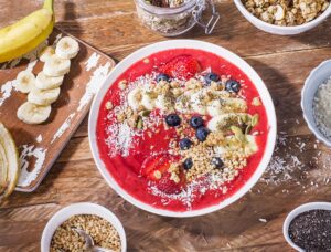 Smoothie-Bowl mit Erdbeeren, Banane, Kokos und Haselnüssen