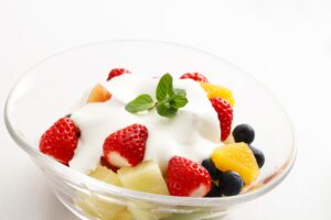 Obstsalat mit Erdbeeren, Orange, Blaubeeren und Sojaquark